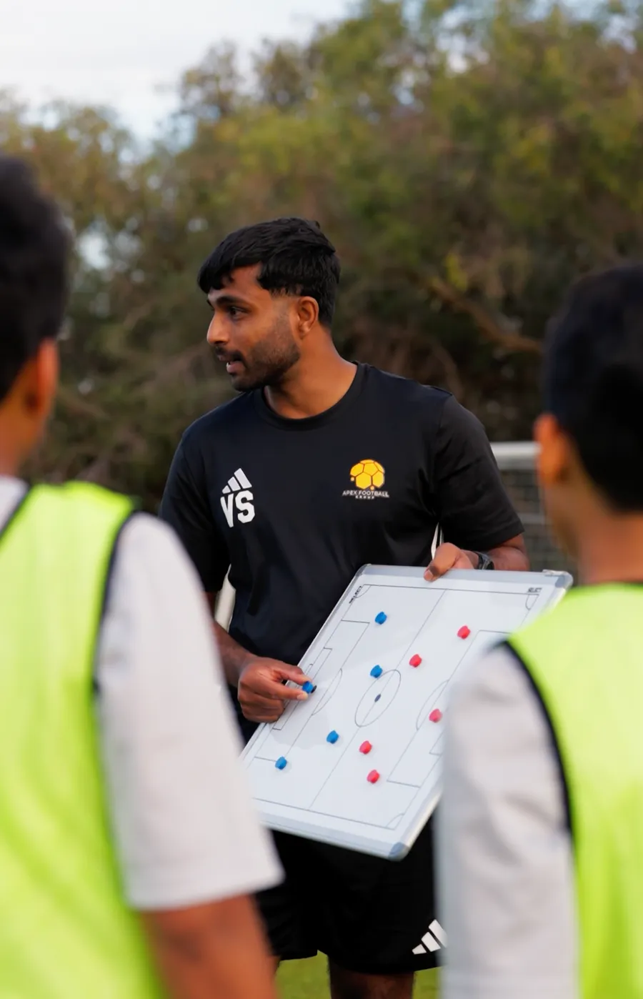 Head coach Vinny talking players through a session on the tactics board