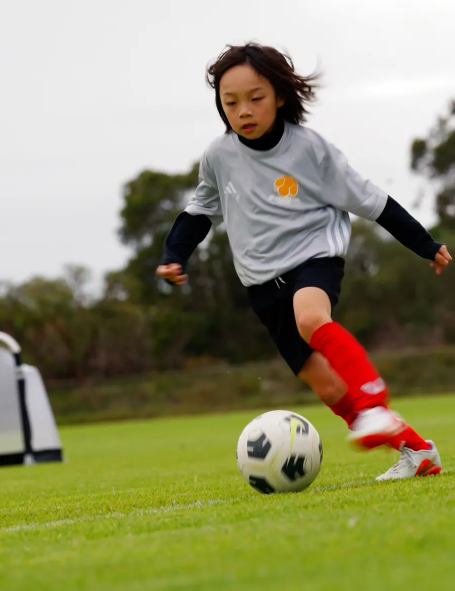 A player driving forward with the ball at training